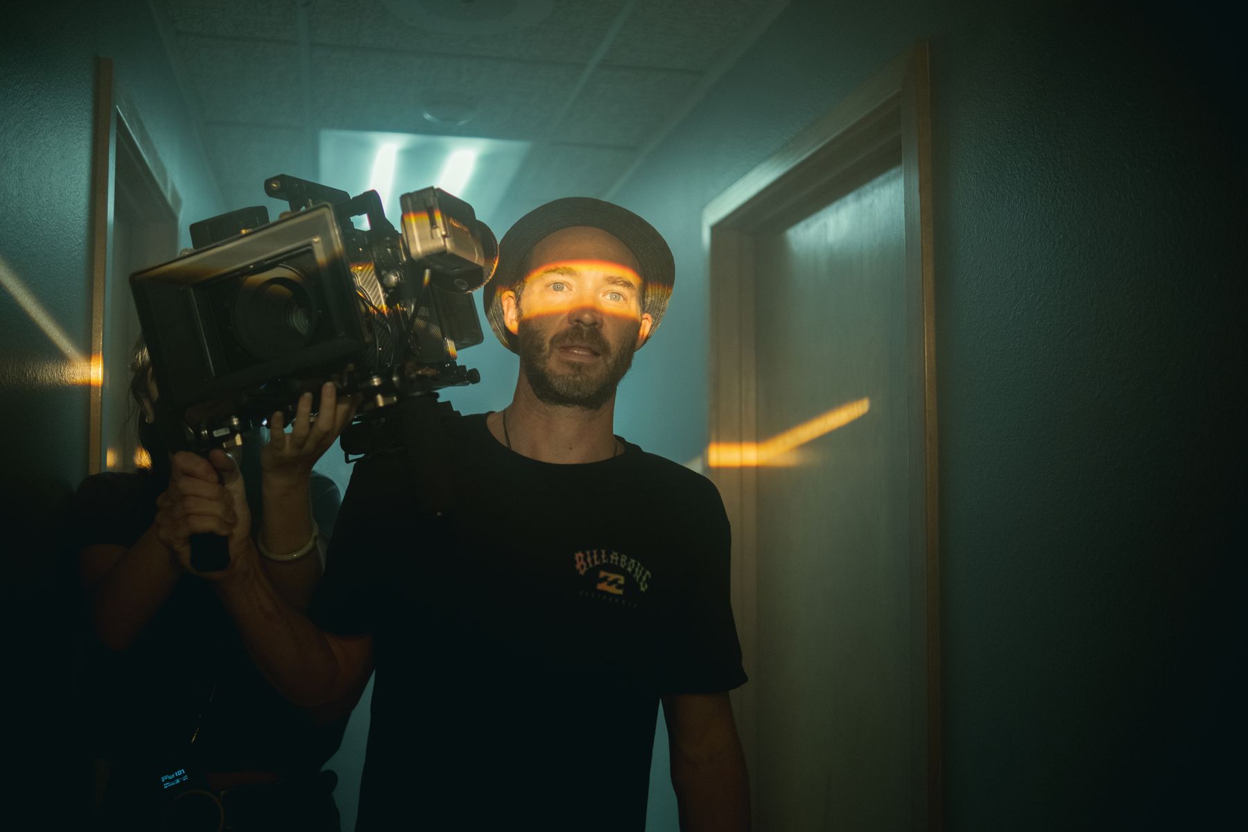 Camera on the shoulder in the teal hallway
