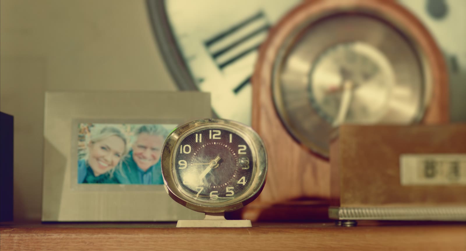 The framed photo of Juniper and her dad beside the clocks in her living room, still from the film