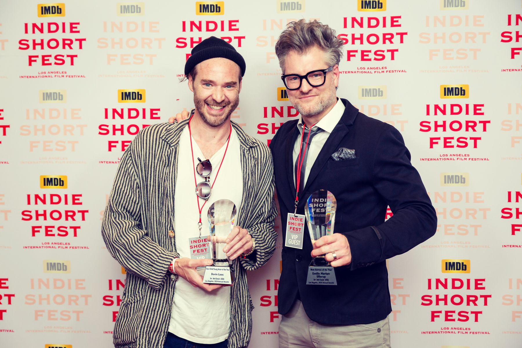 Kyle Cassie and Chris Van Valey holding their trophies on the Indie Short Fest red carpet