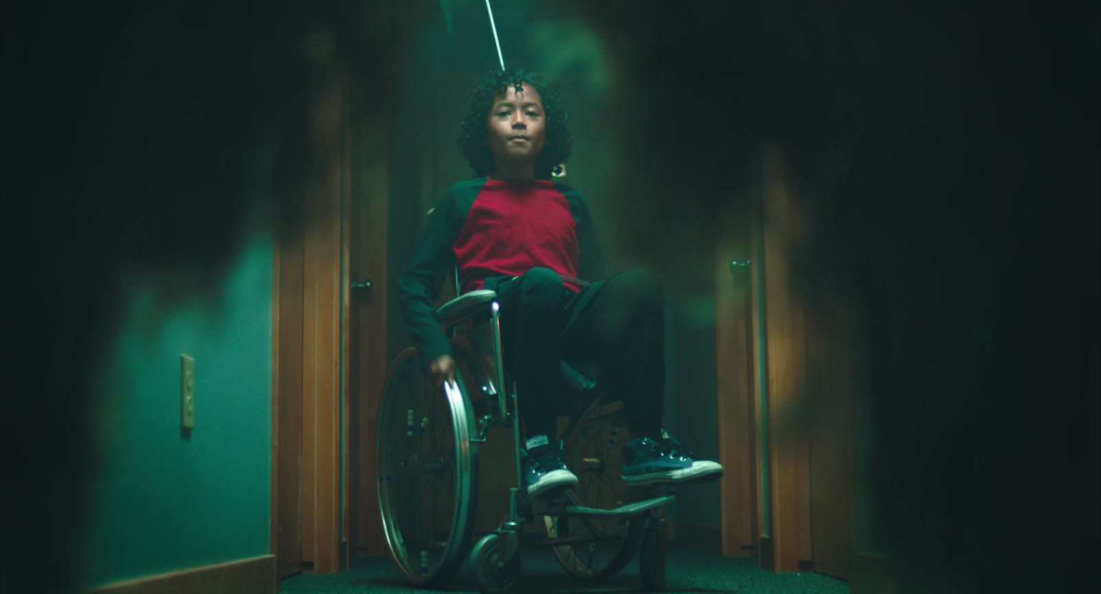 Will in his wheelchair at the end of the building hallway