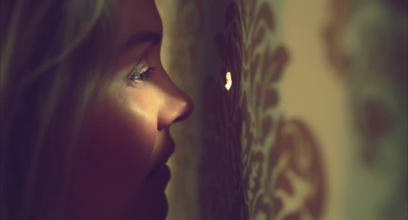 Juniper at the peephole, warm light, still from ANTi-SOCiAL