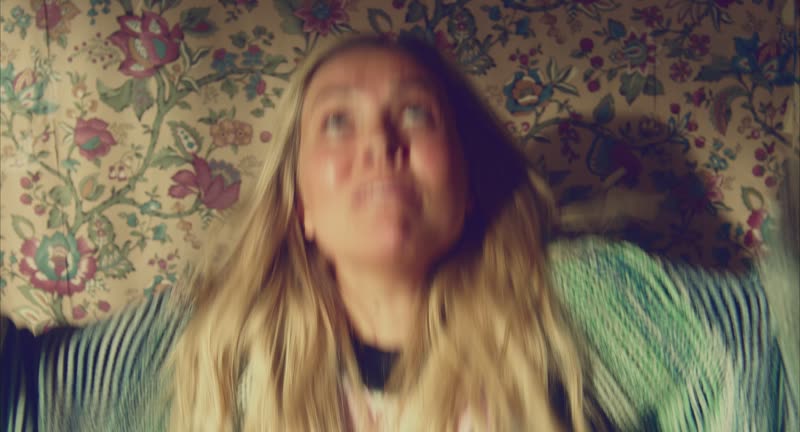 Juniper against the floral wallpaper, still from ANTi-SOCiAL